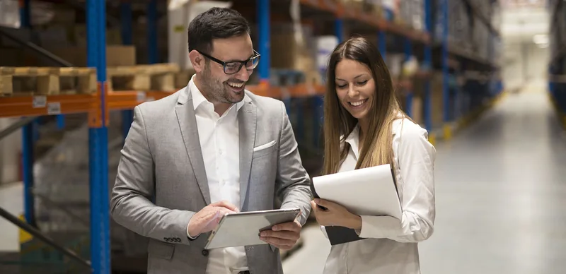 Profissionais consultando informações em um tablet em ambiente empresarial